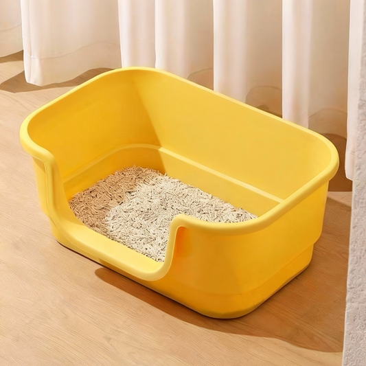 Yellow plastic cat litter box with beige clumping cat litter on wooden floor