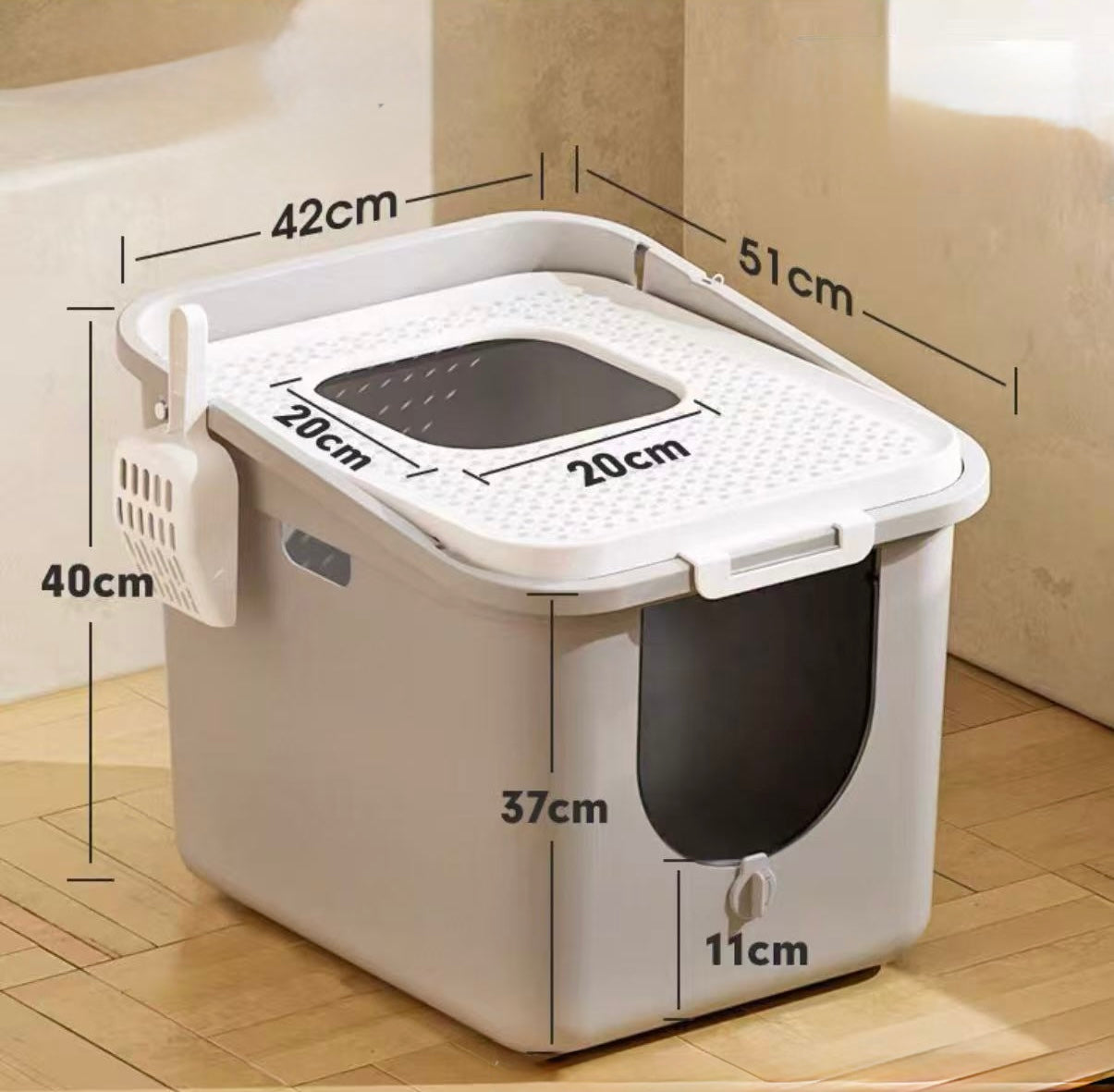 White plastic cat litter box with black door flap and measuring dimensions on beige floor