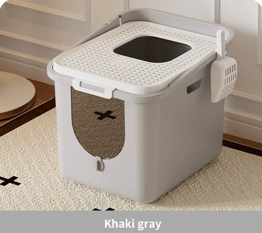 Khaki gray enclosed cat litter box with top entry and attached scoop on beige patterned rug