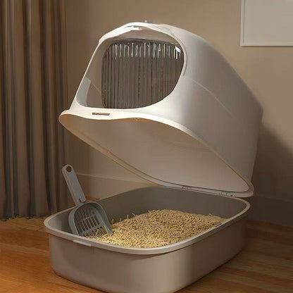 Modern covered cat litter box with scoop and wood pellet litter in indoor setting