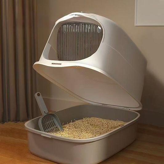 Modern covered cat litter box with scoop and wood pellet litter in indoor setting