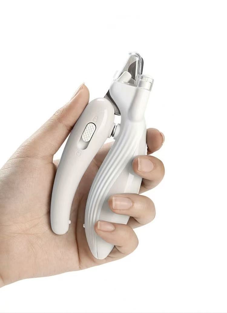 Hand holding white electric pet nail grinder and clipper grooming tool