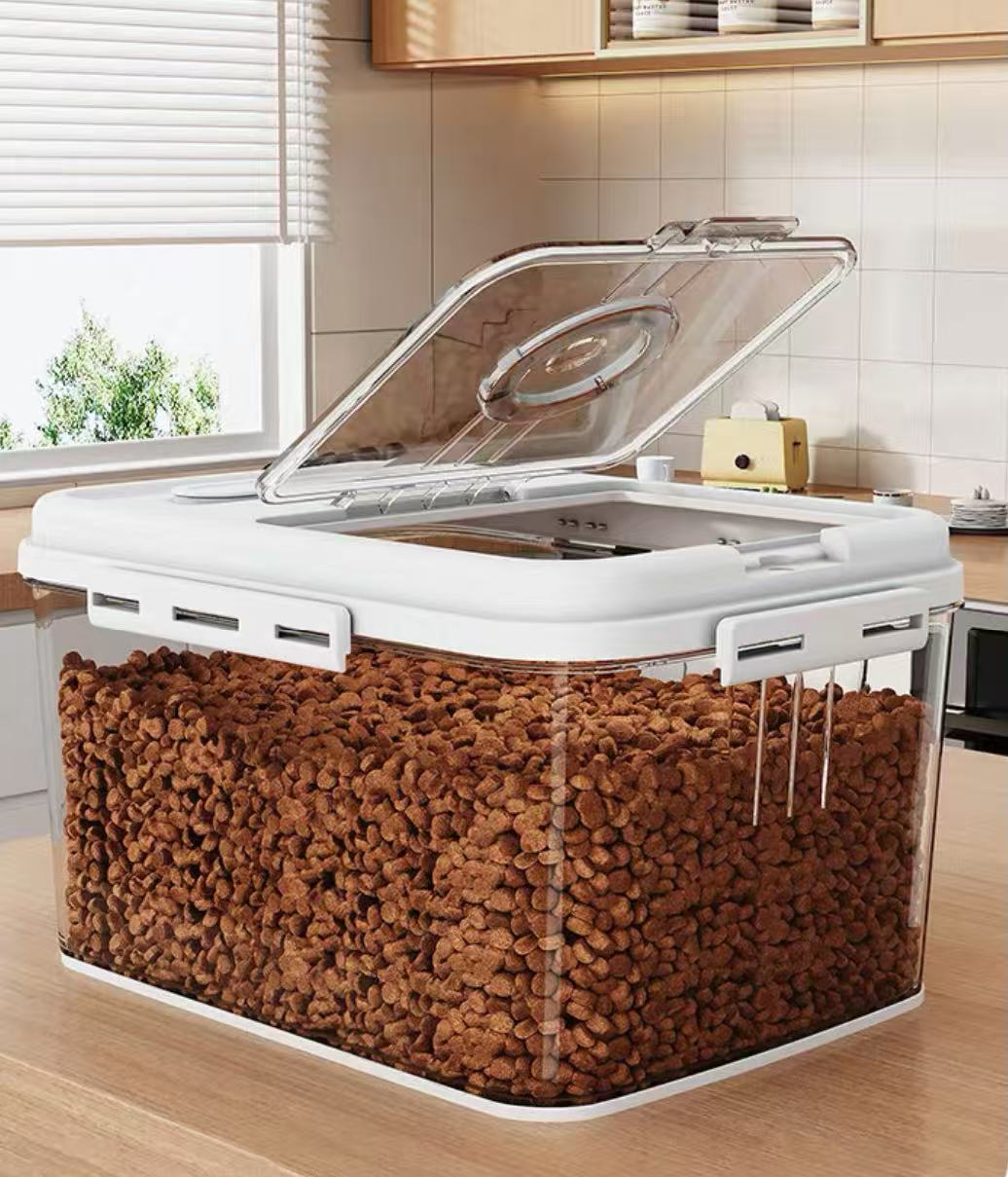 Clear plastic airtight pet food storage container filled with brown kibble on kitchen counter
